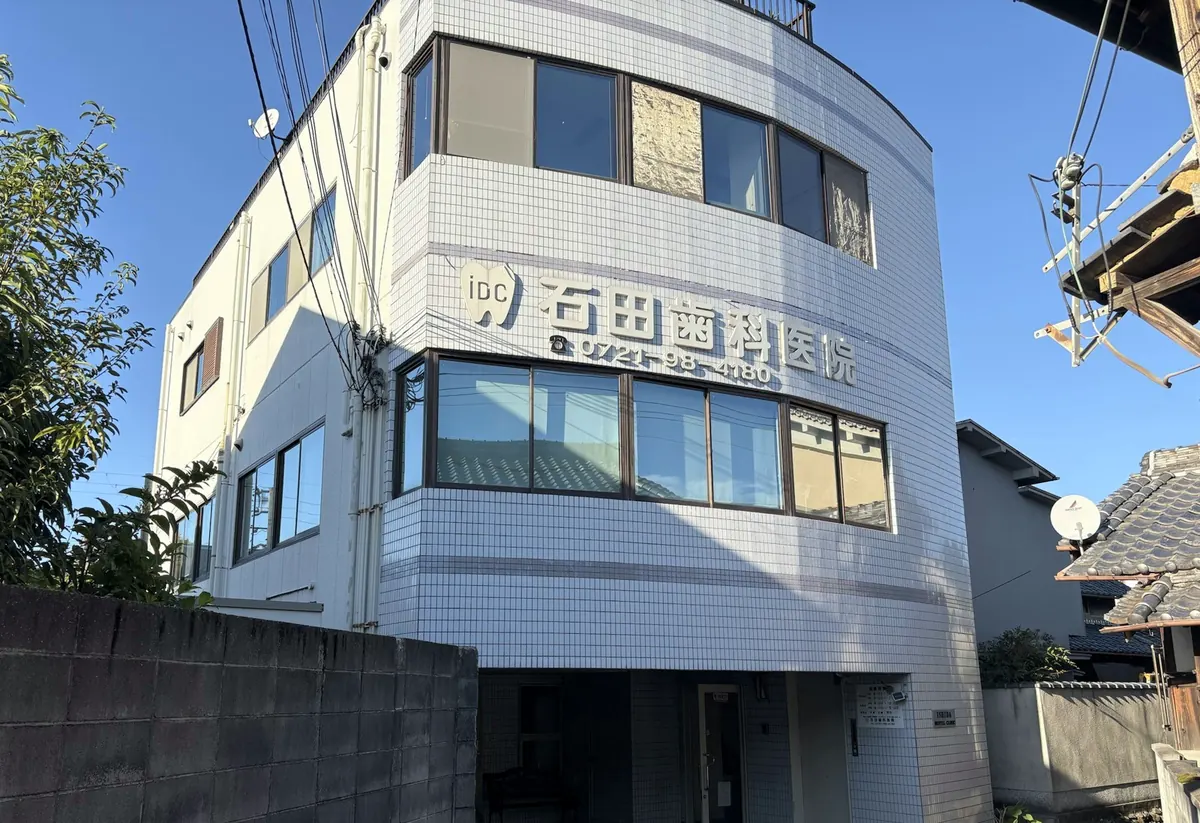 石田歯科医院の外観。2階の壁に医院名と電話番号の看板